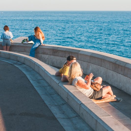 des gens discutent sur le bord de mer à Nice